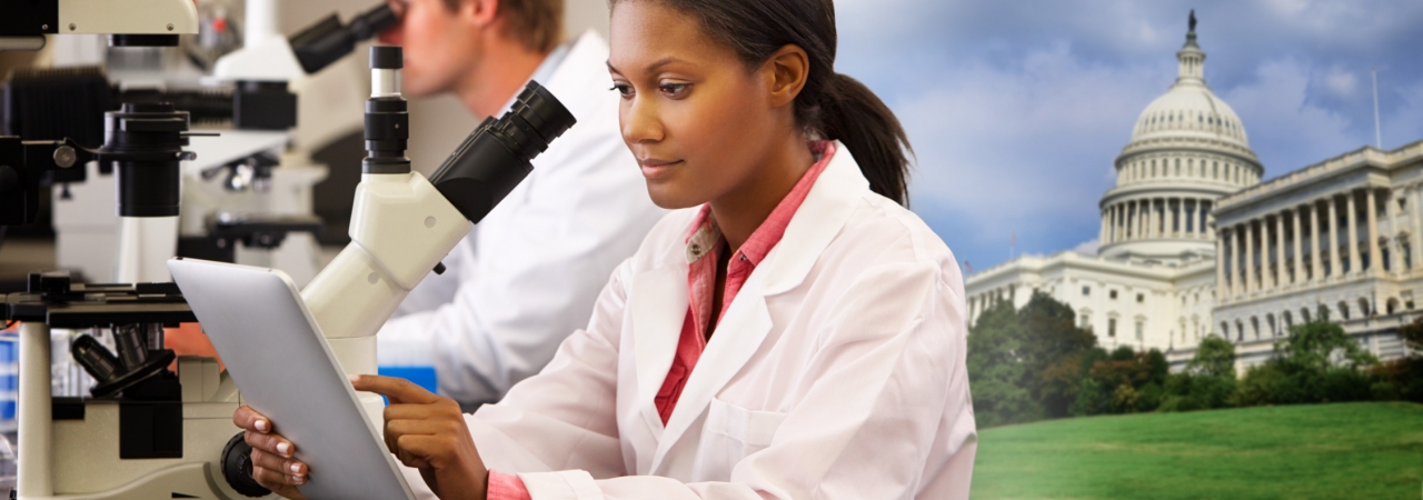 Read "Making Tobacco-related Death Part of America’s Past". A woman scientist using a microscope.