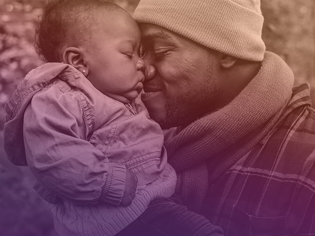 Father warmly embracing and pressing face against child's face