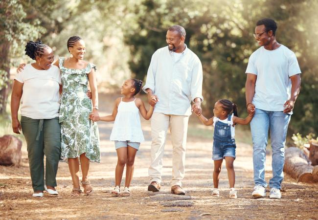 Family holding hands walking at a park. 