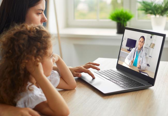 Mother and child speaking with doctor over a video call.