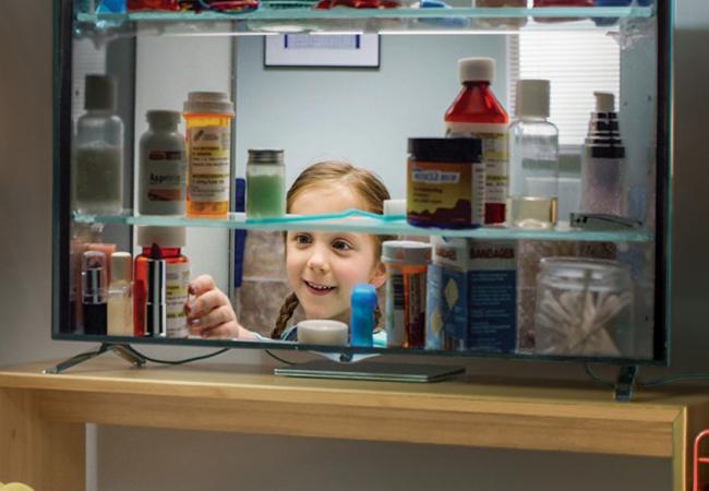 A still from a television promotion to remove the risk of unused opioids that depicts a child opening a medicine cabinet