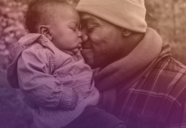 Father warmly embracing and pressing face against child's face