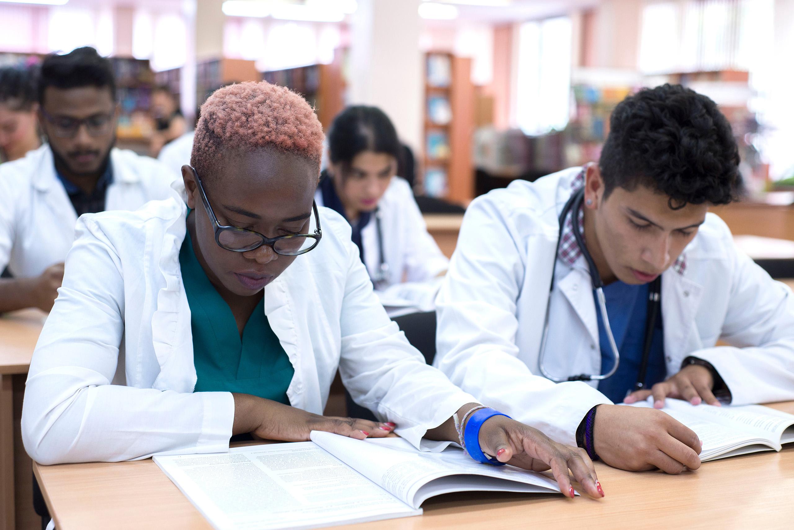 Nurses sitting in a classroom and reading medical literature